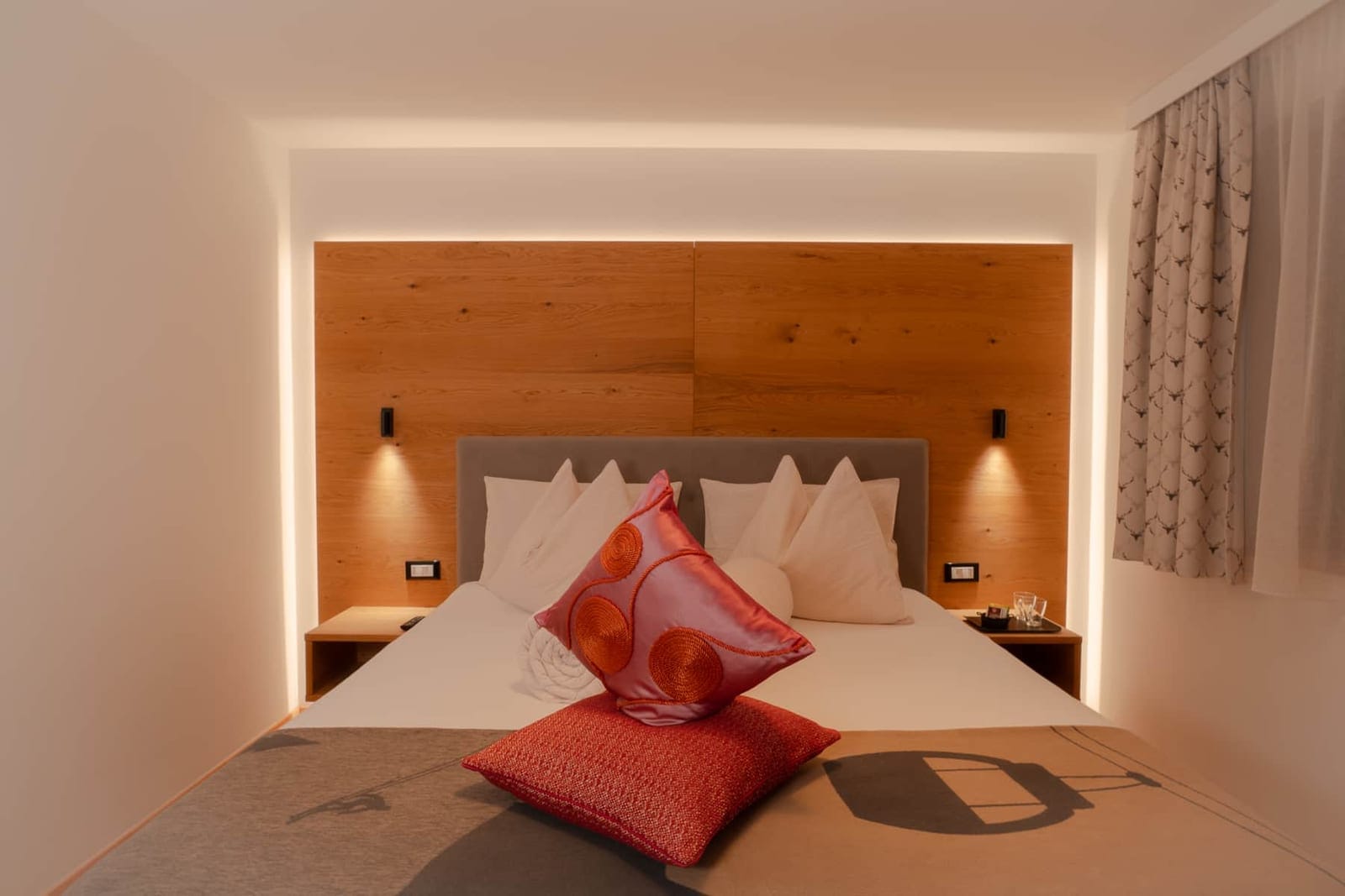 La Möra: camera da letto con testata in legno e luce soffusa.