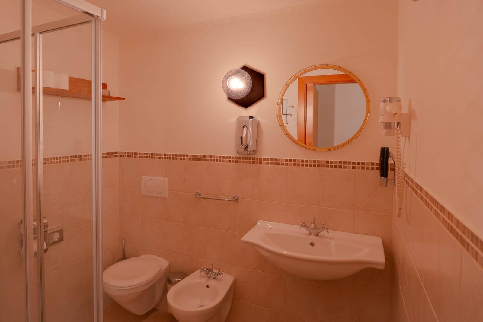 Ladin Spirit: bagno con doccia e specchio rotondo.