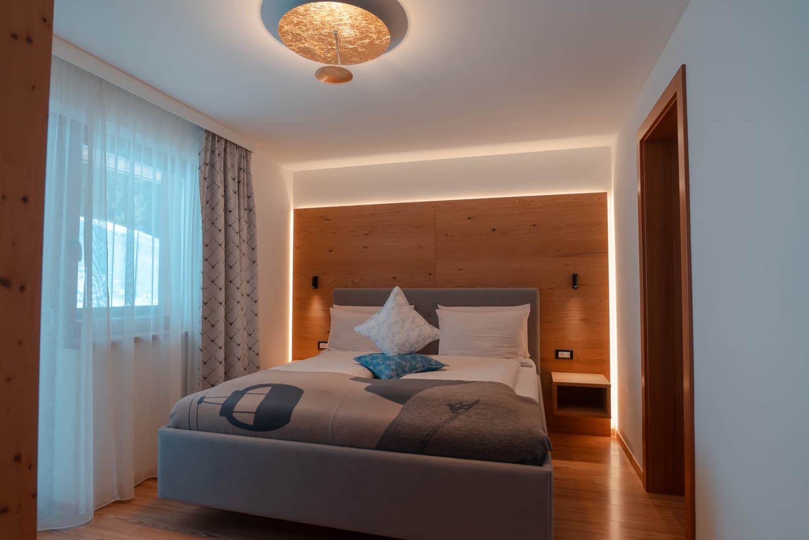 Ladin Spirit: camera matrimoniale con testata in legno.