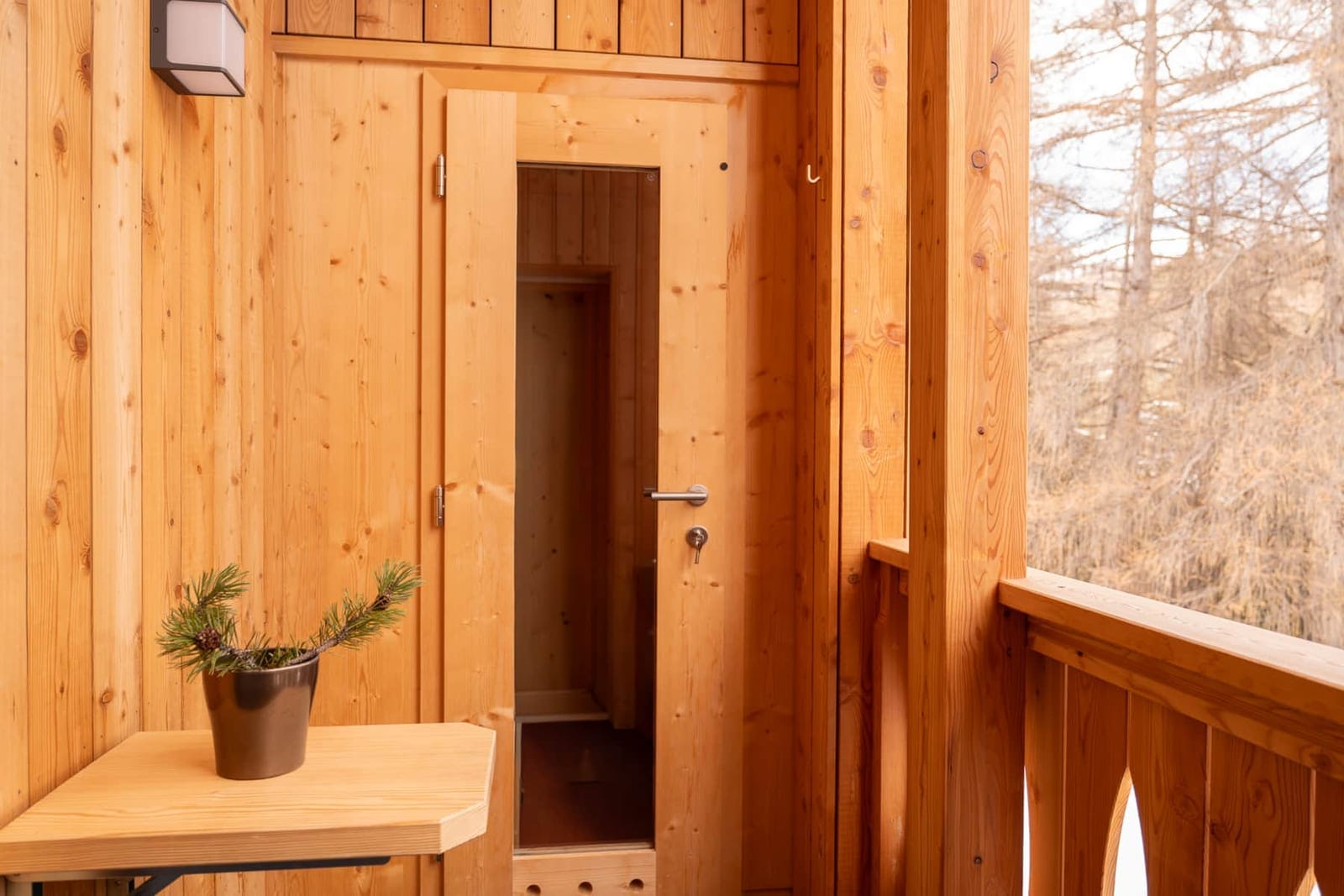 Montaria: balcone con la porta della sauna privata e i larici.