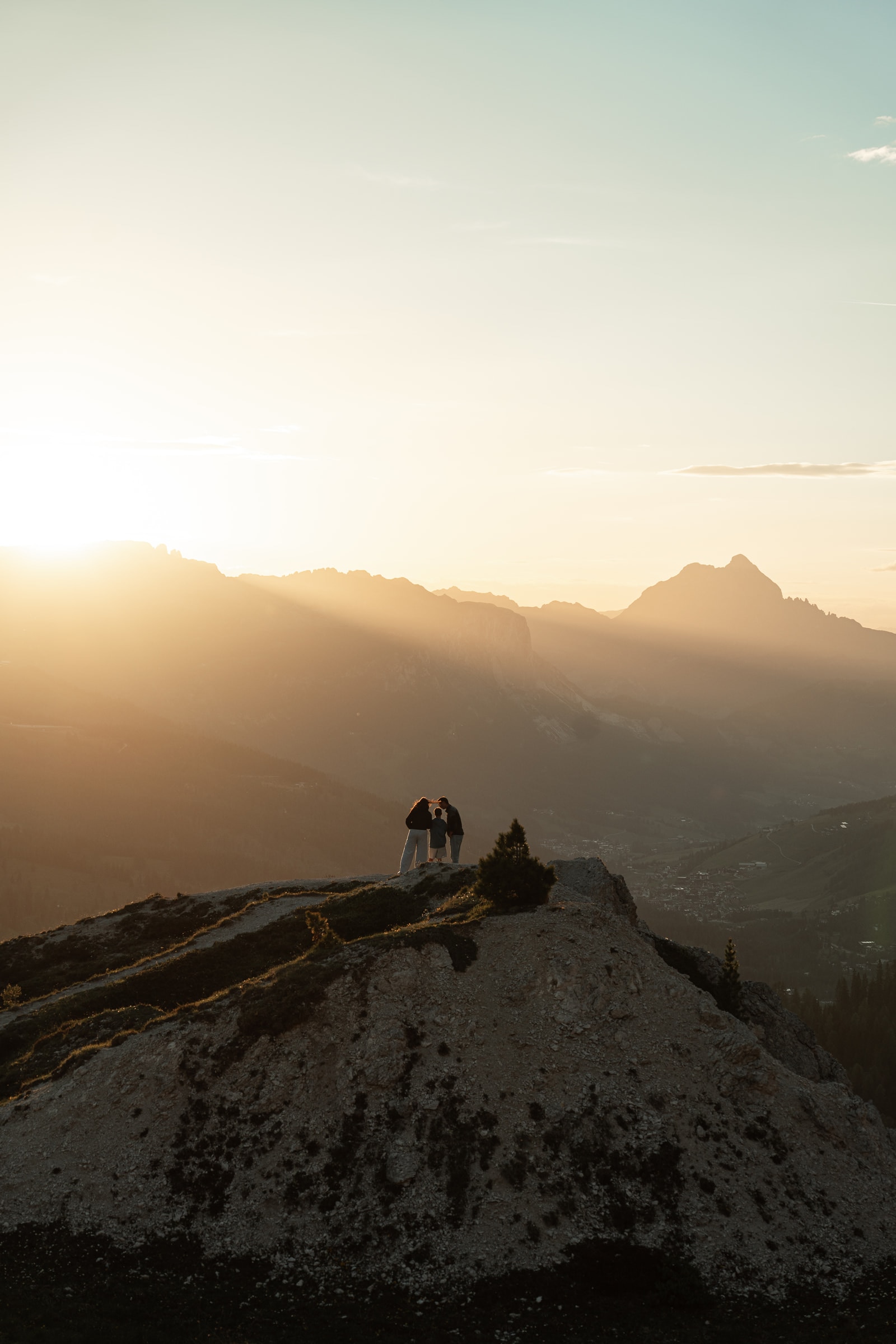 Silhouetten auf einem Bergrücken, mit Sonnenstrahlen über dem Tal.
