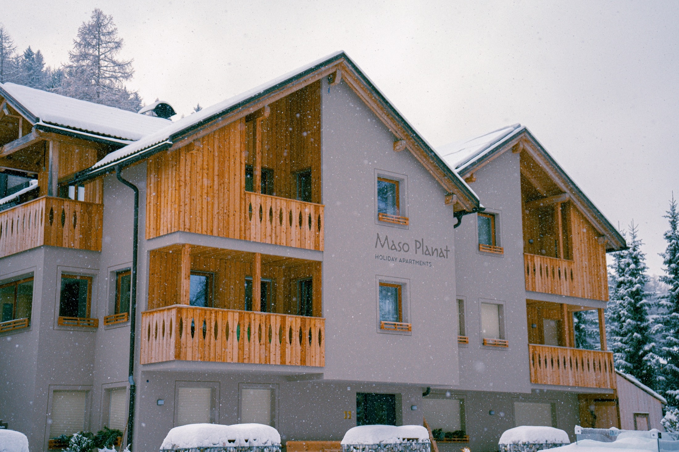 Facciata di Planat in inverno, neve e legno a San Cassiano.