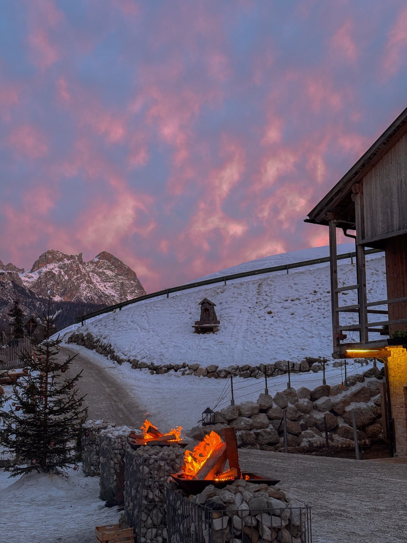 Fuoco invernale all'aperto presso Planat, cielo rosa.